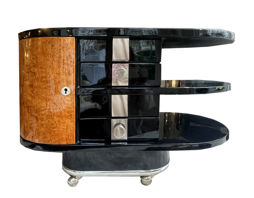 Art Déco Barwagen oder Beistelltisch auf Rollen Frankreich um 1930. Vogelaugenahorn mit Schwarzlack. Von beiden Seiten halbrunde furnierte Türen in Vogelaugenahorn, 2 Schubladen und schwarze Glasplatte. Auf Rollen stehend.Sockel umrahmt von Aluminium Leiste. Beschläge vernickelt. Höhe: 57,5 cm| Breite: 80 cm |Tiefe:41cm  Nr.2707