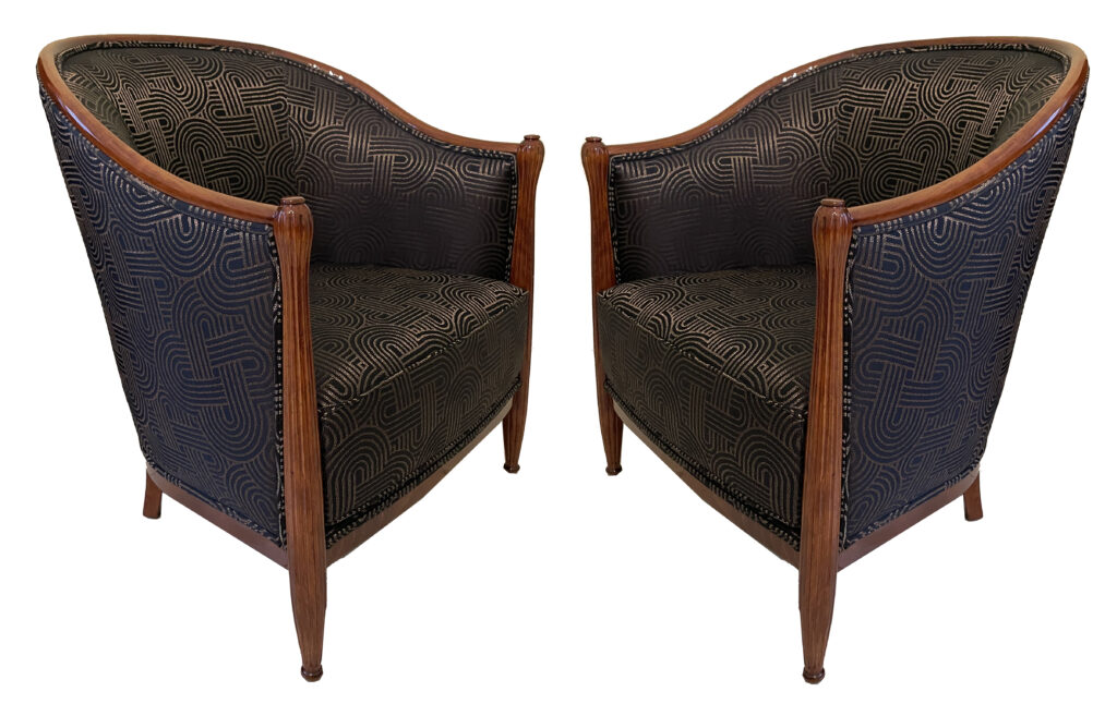 Elegant pair of armchairs from France Art Deco Bergère style France circa 1925 Stained beech. Newly reupholstered and padded. Finely fluted columns with finials; curved, upward-sloping backrests, slightly tapered at the front and gently reclined at the back.