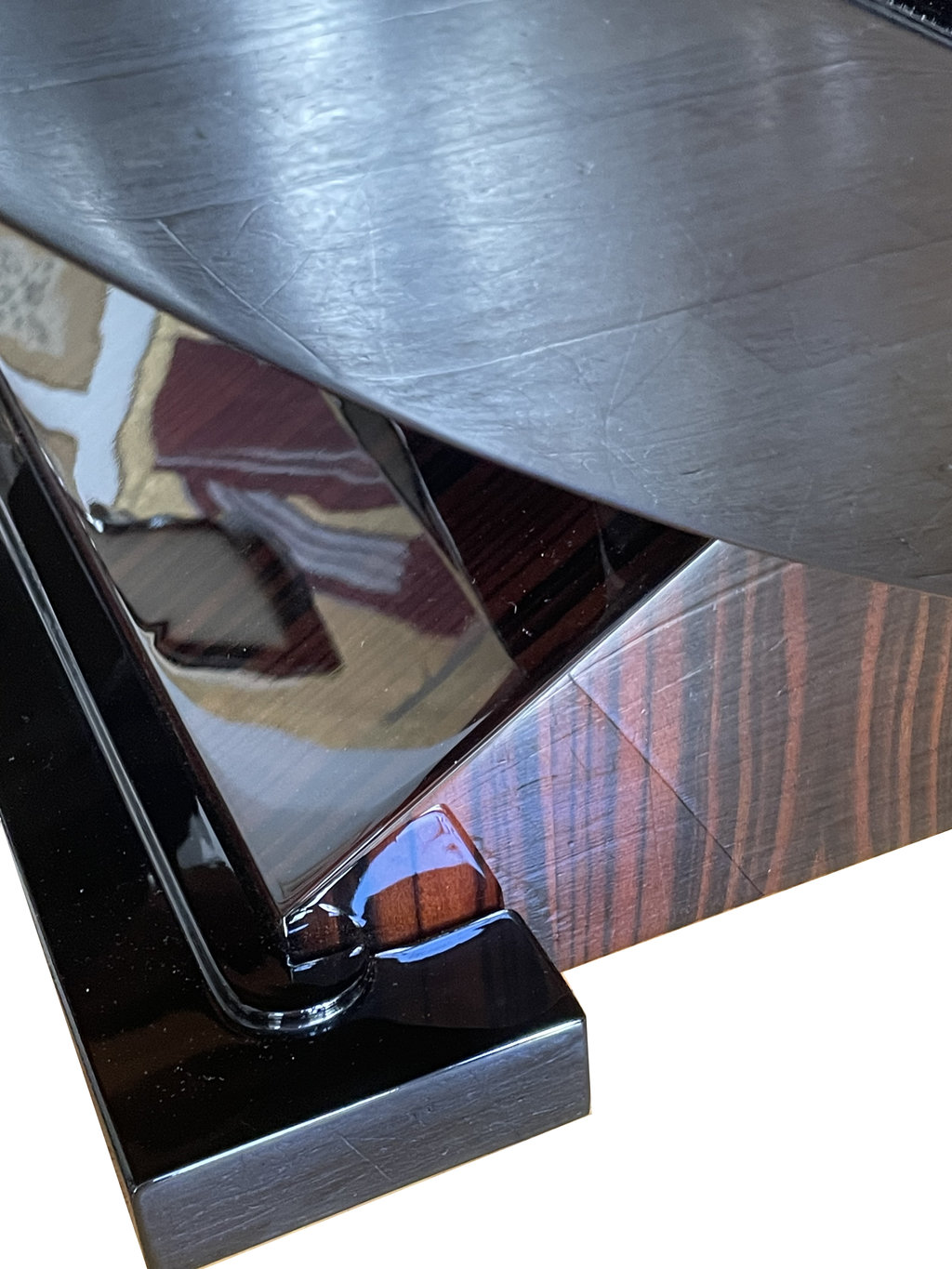 The design of the base highlights the fine craftsmanship—featuring black lacquer accents and an interplay between straight lines and rounded forms.