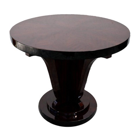 Full view of the round mahogany table with its sculptural central support and stepped foot