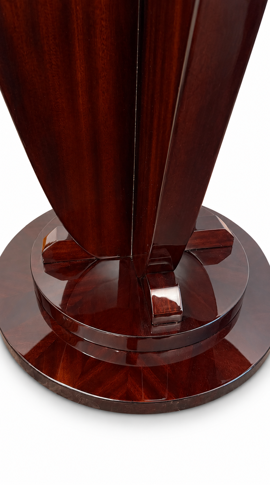 Close-up of the polished, stepped circular base and lower ends of the curved supports