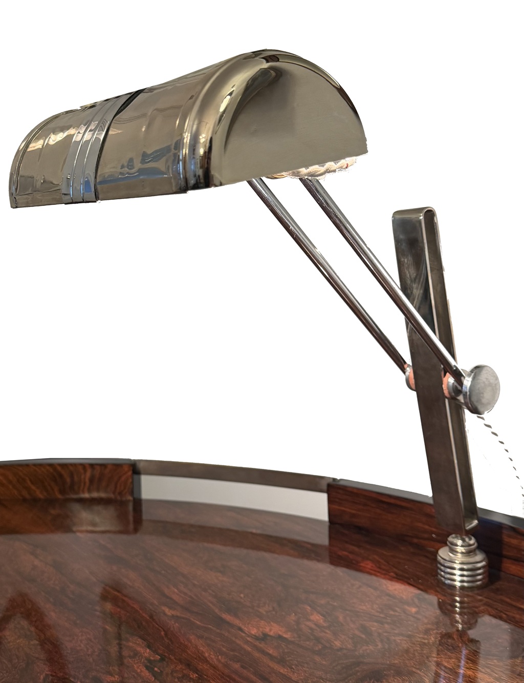 Close-up of the chrome-plated lamp with curved shade and adjustable arm on the desk