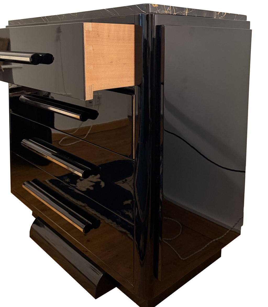 <br>Angled side view showing the black lacquer finish and long handles on the four drawers