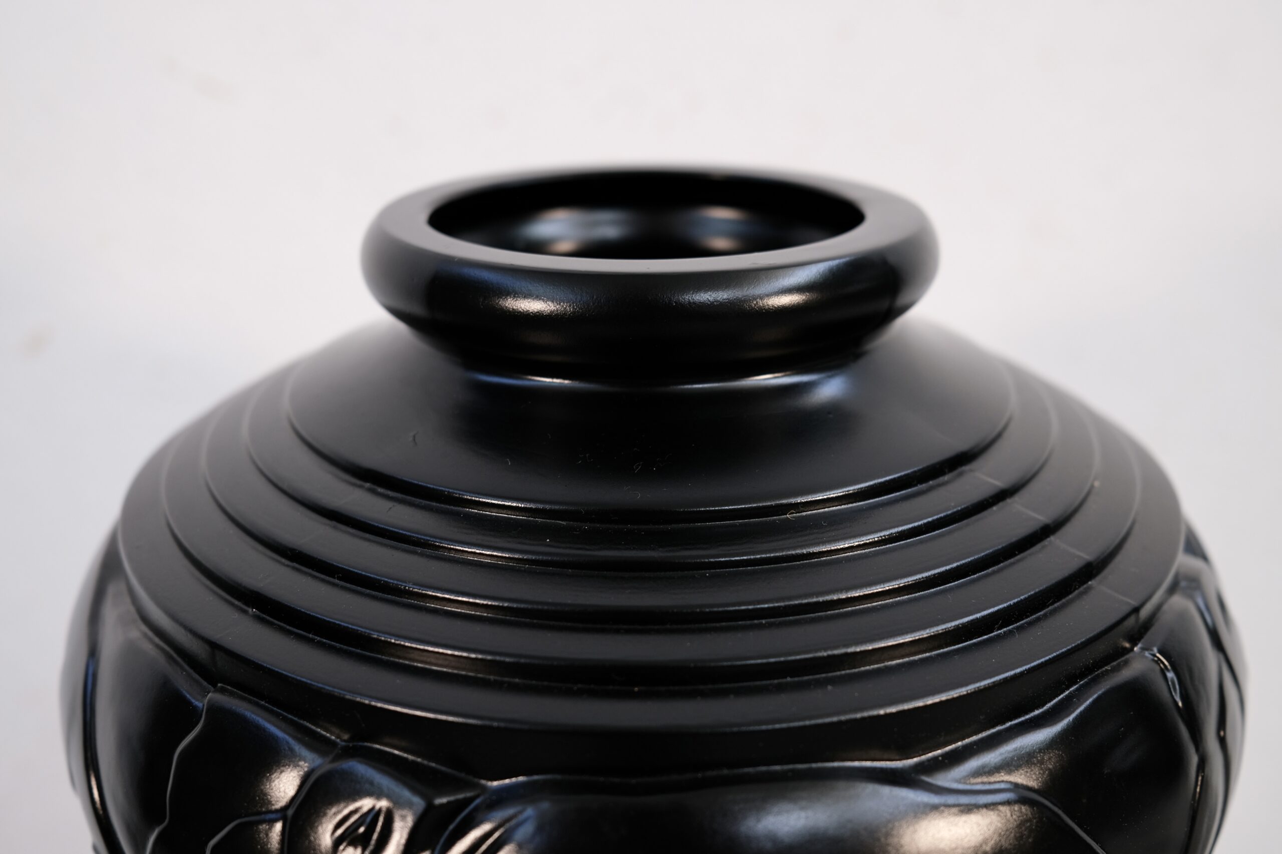 Close-up of the narrow opening and stepped shoulder of the black Art Deco vase