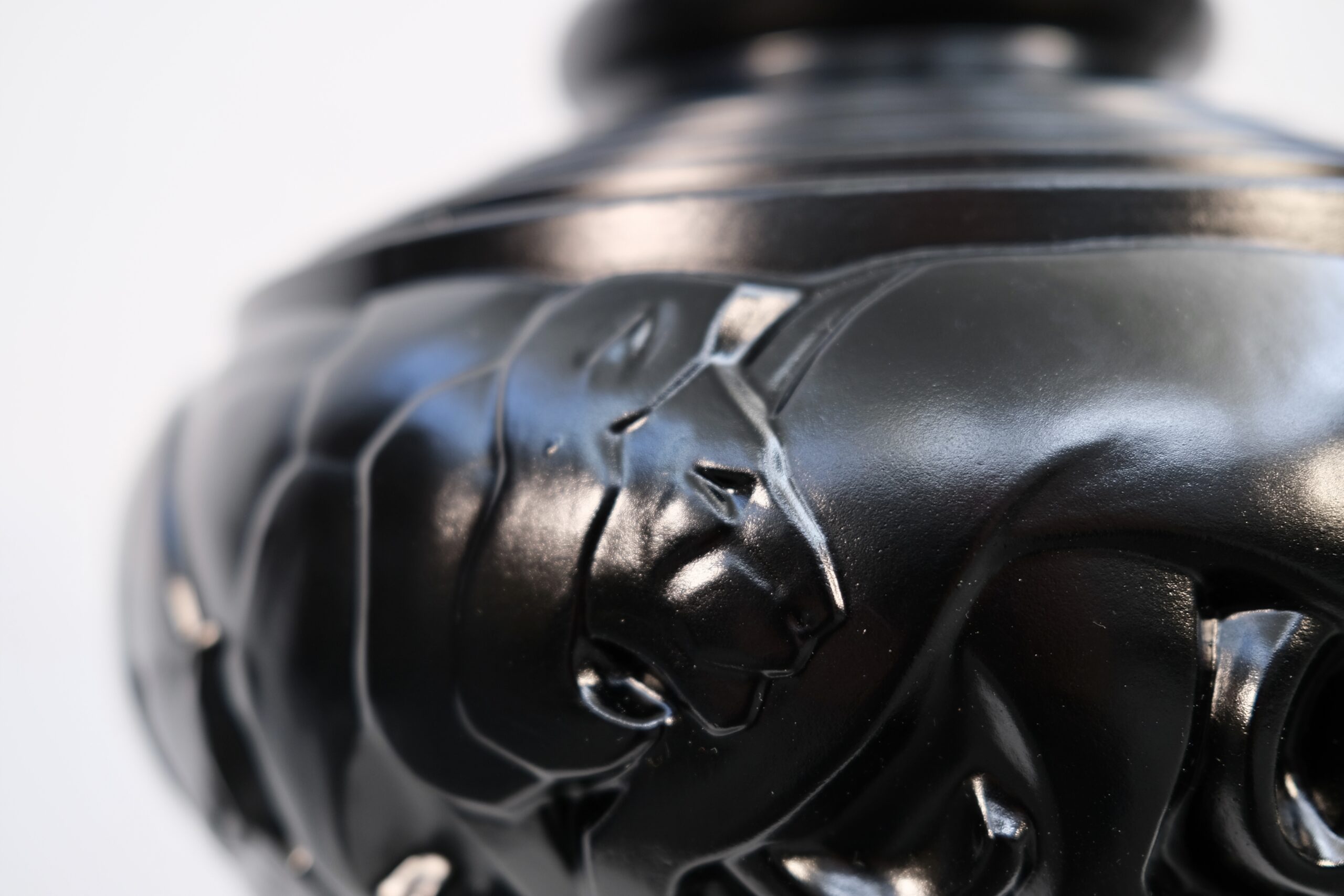 Close-up of a lion’s head in relief on the black Pierre d’Avesn vase